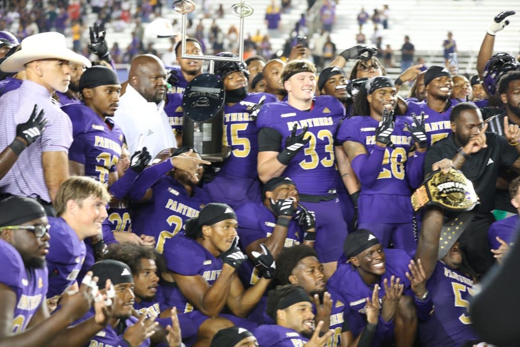 Prairie View A&M Team celebrating State Fair Classic Winners victory with trophy.