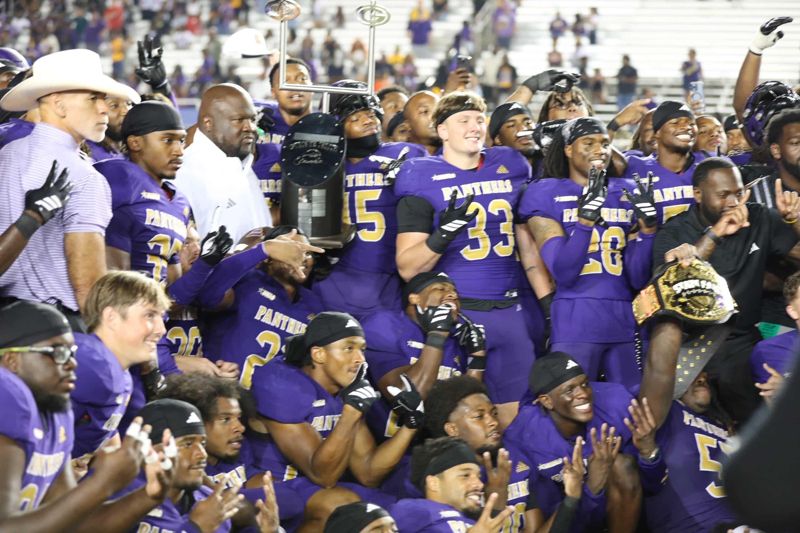 Prairie View A&M Team celebrating State Fair Classic Winners victory with trophy.