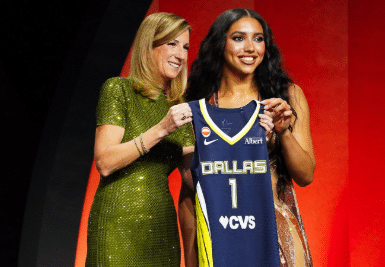 Azzi Fudd holding WNBA Dallas wings Draft basketball jersey