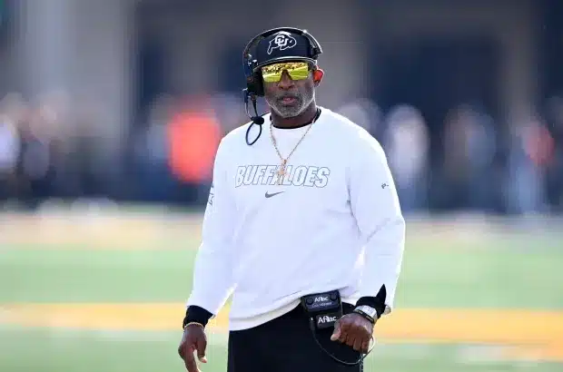 Coach Deion Sanders wearing sunglasses and headset